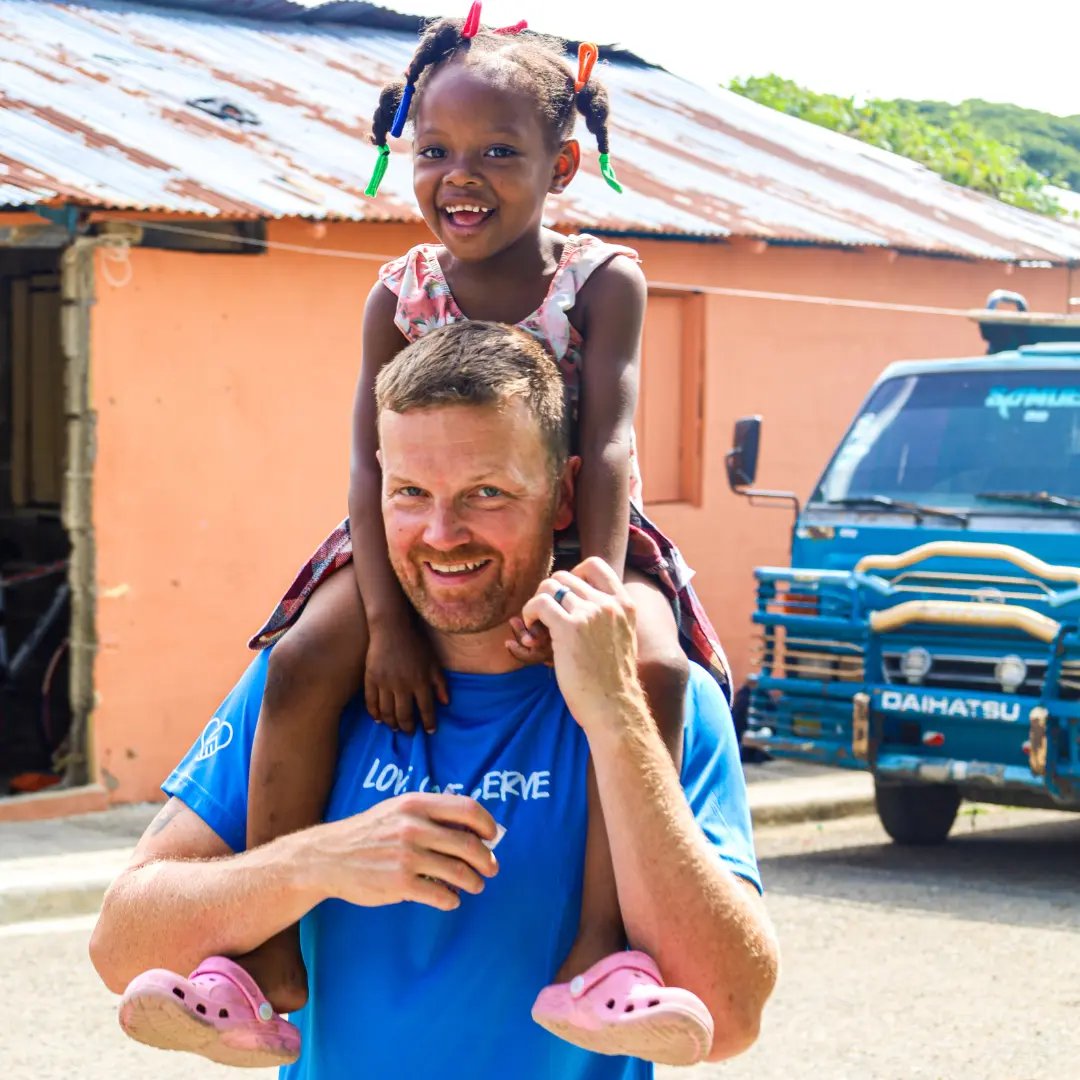 Dedicated Financial GBC CEO and Founder with a child during the annual Dominican Republic service trip