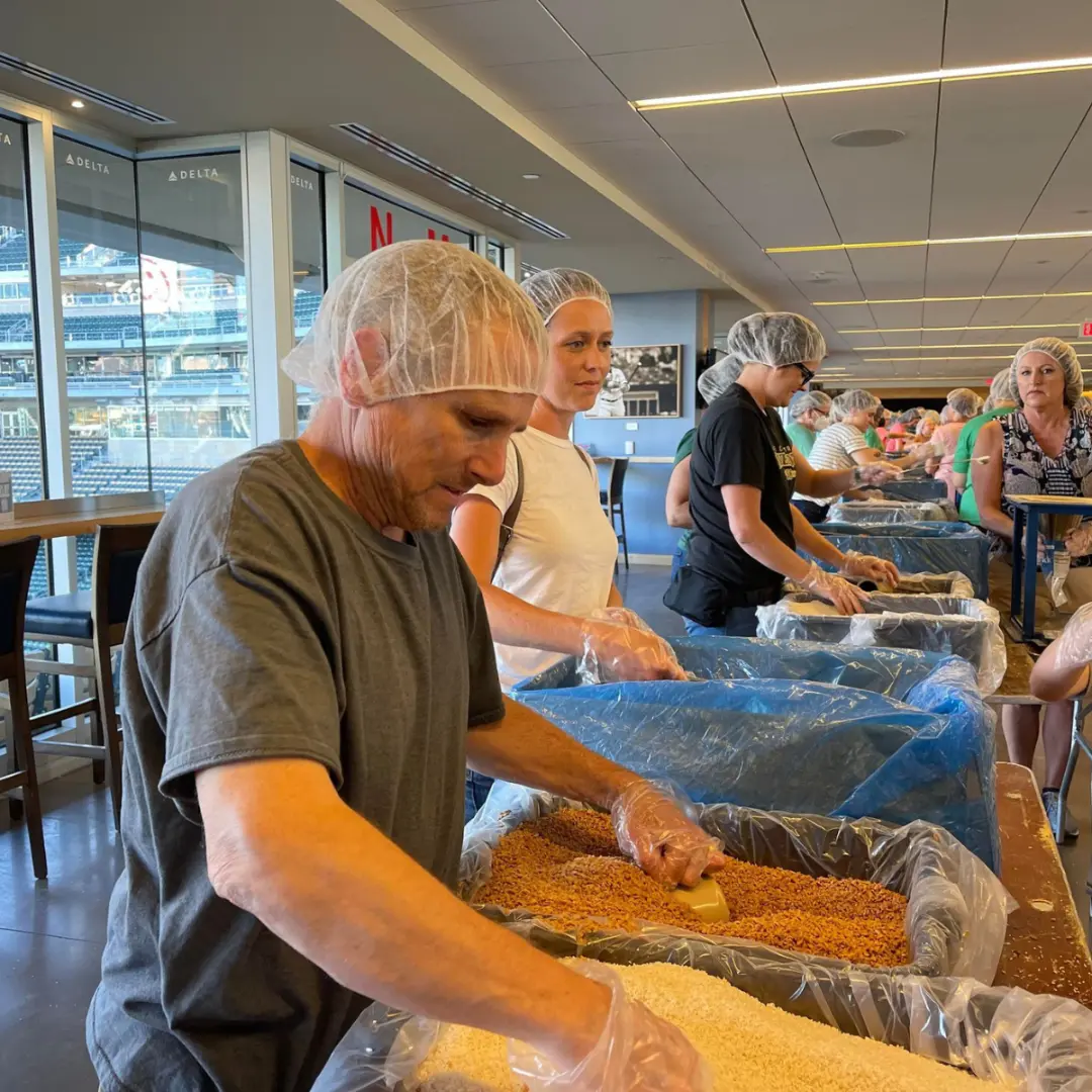 Dedicated Financial GBC collector volunteering at Feed My Starving Children as part of a purpose-driven business