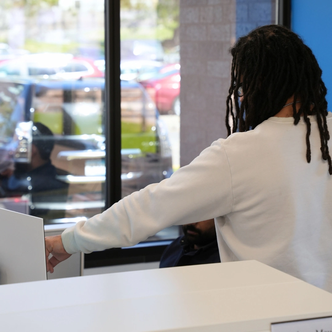 Dedicated Financial GBC team member assisting a colleague at a desk in the office